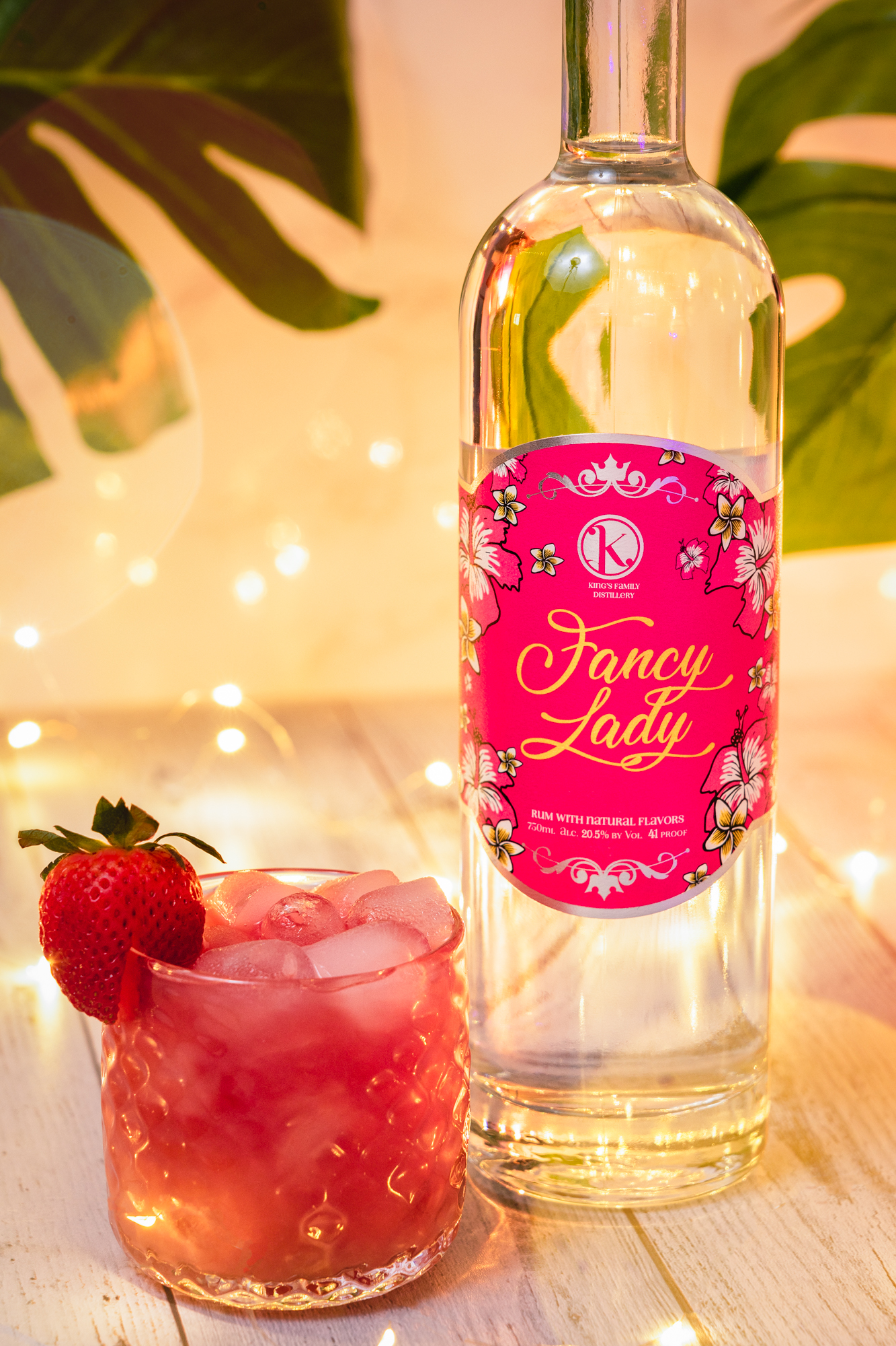 Fancy Lady Rum with a pink label next to a strawberry cocktail